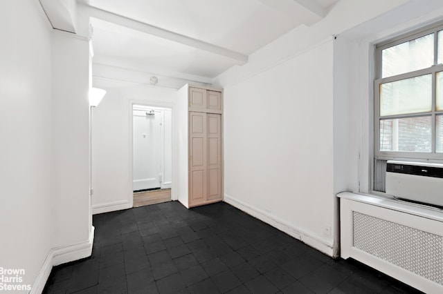 35 W 9th St Unit 1B, New York City, NY 10011 - unfurnished room with radiator heating unit, beam ceiling, dark tile patterned floors, and baseboards