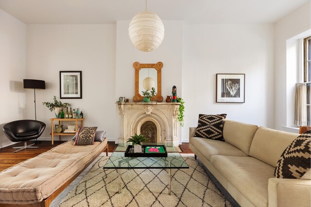 living room with a fireplace, baseboards, and wood finished floors