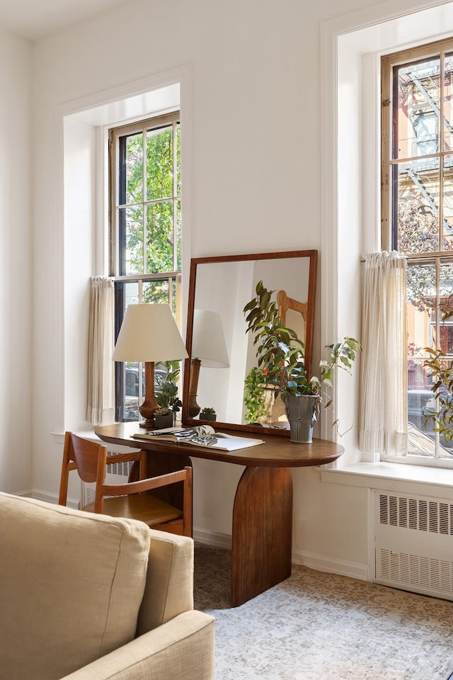 carpeted office featuring baseboards and radiator heating unit