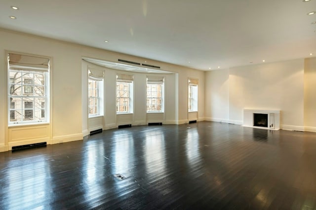 unfurnished living room with baseboards, a fireplace, wood finished floors, and recessed lighting