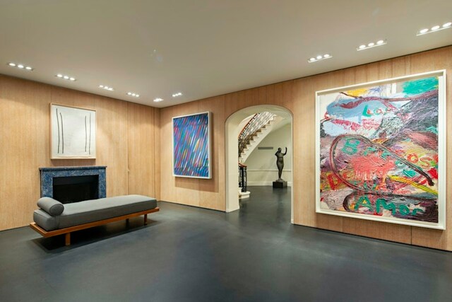 sitting room featuring a high end fireplace and wood walls