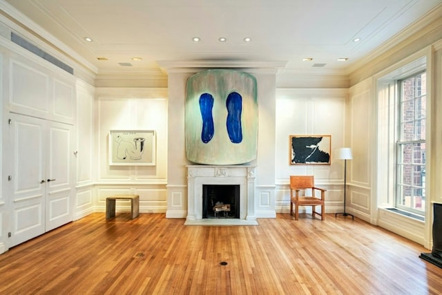 unfurnished living room featuring plenty of natural light, ornamental molding, and light wood-type flooring