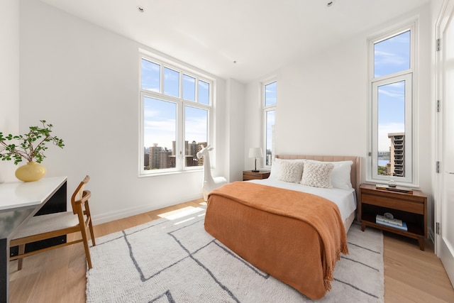 bedroom featuring multiple windows and light hardwood / wood-style flooring