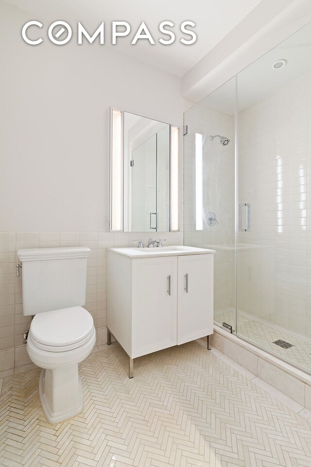 100 Barclay St Unit 13K, New York City, NY 10007 - full bath featuring vanity, toilet, tile walls, tiled shower, and a wainscoted wall