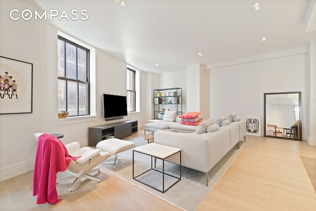 living area with light wood-style flooring and baseboards