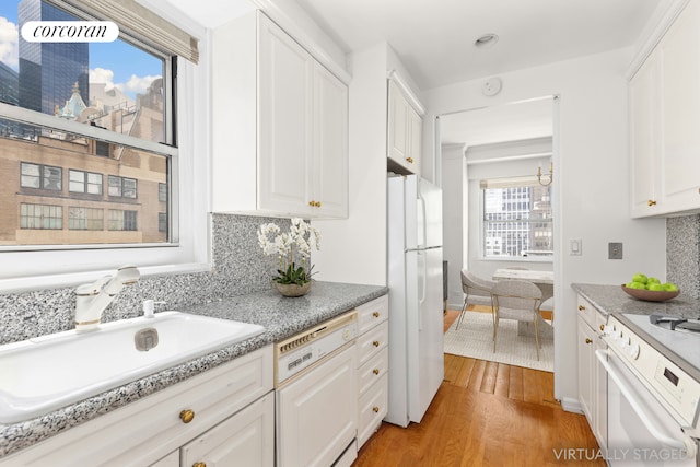 kitchen featuring light hardwood / wood-style floors, tasteful backsplash, white appliances, white cabinets, and sink