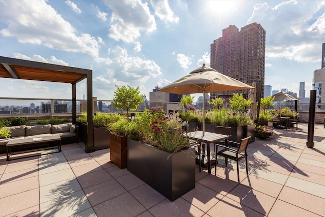 view of patio featuring a city view, fence, outdoor dining area, and an outdoor hangout area