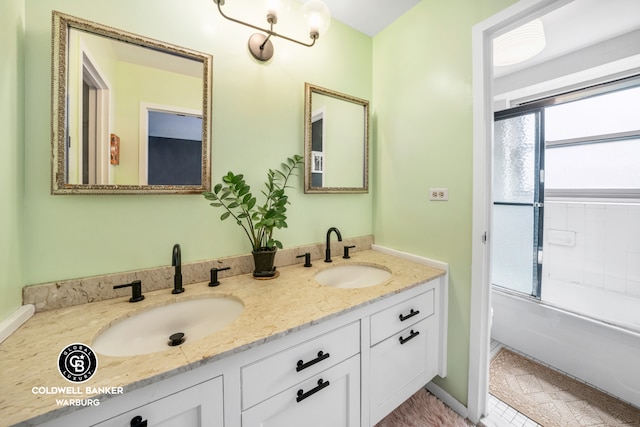 full bathroom with combined bath / shower with glass door, a sink, and double vanity