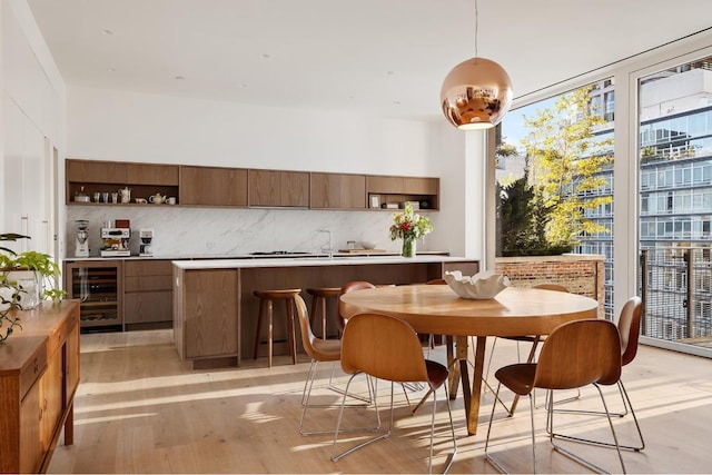 dining room with wine cooler and light hardwood / wood-style flooring