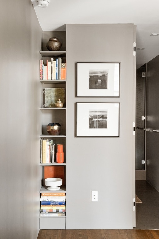 interior space with built in shelves and hardwood / wood-style floors