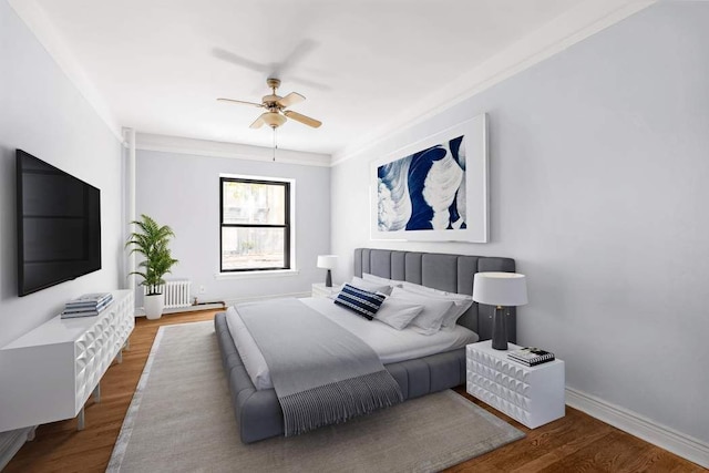 bedroom featuring radiator heating unit, crown molding, wood-type flooring, and ceiling fan