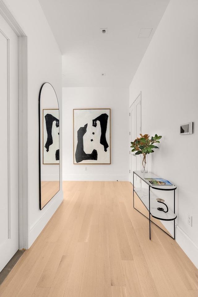 corridor featuring wood finished floors and baseboards