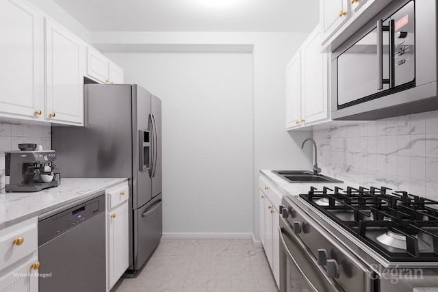 kitchen featuring tasteful backsplash, sink, white cabinets, stainless steel appliances, and light stone countertops