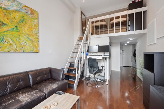 living room with dark wood-type flooring and a towering ceiling