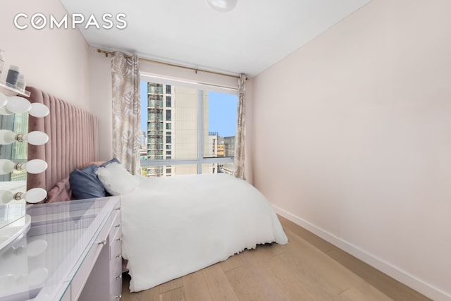 bedroom with light wood-style floors and baseboards