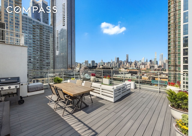 wooden deck featuring a city view and a grill