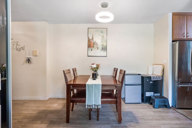 dining area with light wood-style flooring and baseboards