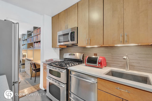 kitchen featuring stainless steel appliances, backsplash, a sink, and light stone countertops