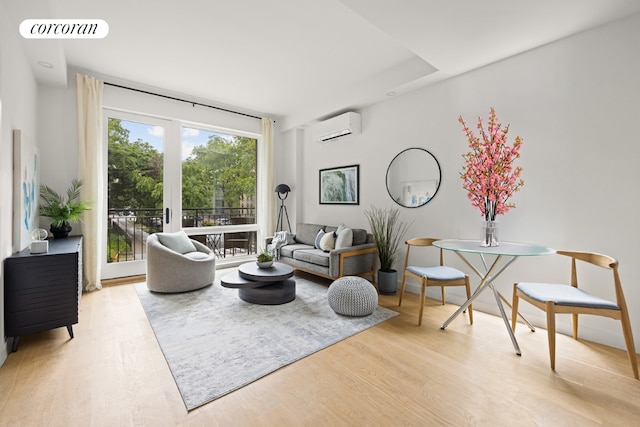 living room featuring light wood-type flooring and a wall unit AC