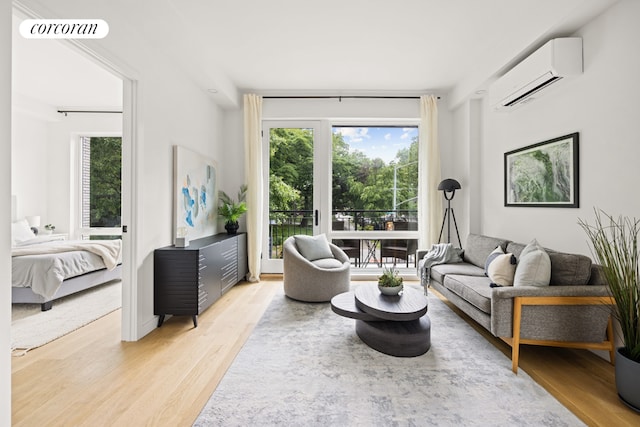 living room featuring light wood-type flooring and a wall mounted air conditioner