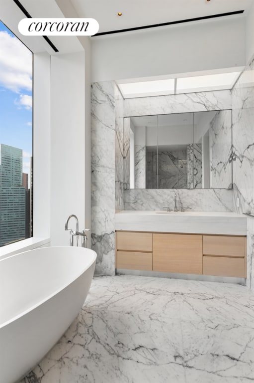 bathroom featuring vanity and a bath