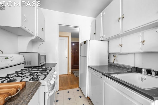 kitchen featuring white cabinetry, white appliances, sink, and light tile patterned floors