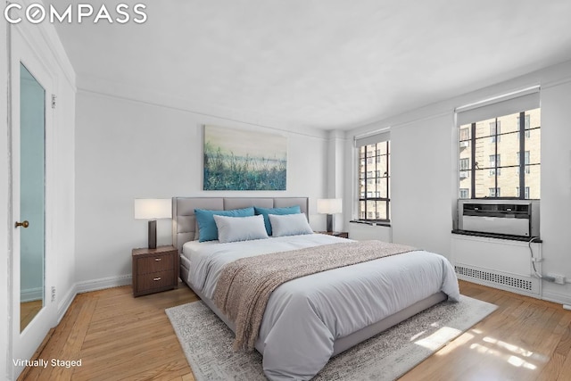 bedroom with cooling unit and light wood-type flooring