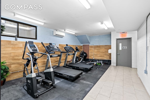 workout area with a wall mounted air conditioner and concrete block wall