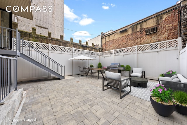 view of patio with area for grilling, outdoor dining space, and a fenced backyard