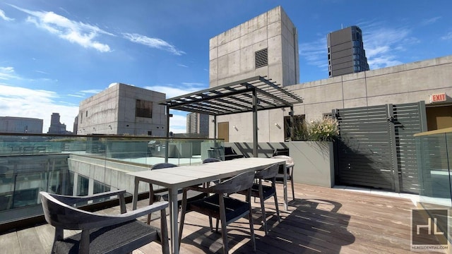 deck with a view of city, outdoor dining space, and a pergola