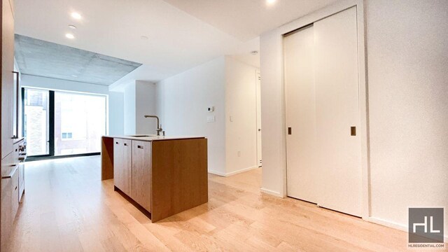 laundry room featuring hardwood / wood-style flooring and stacked washer / drying machine