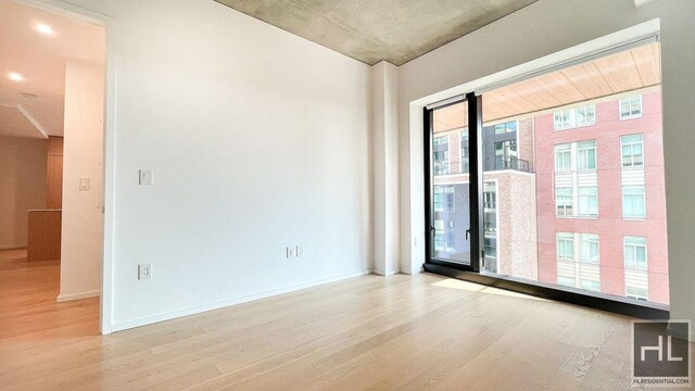 empty room with baseboards and wood finished floors