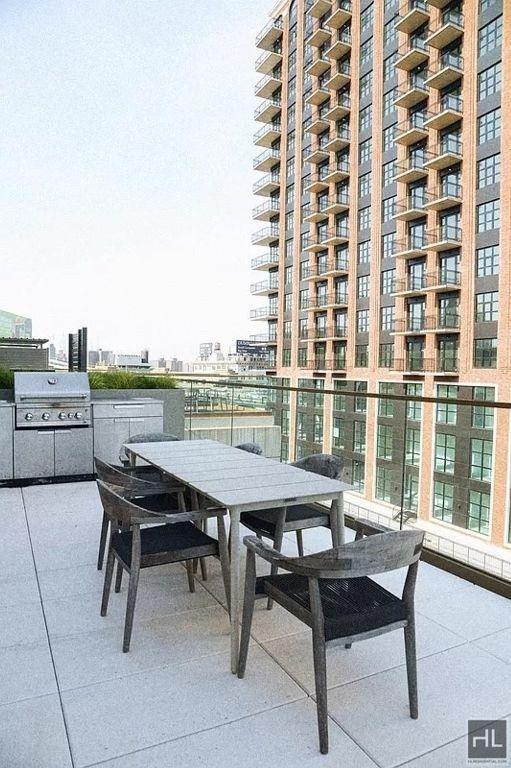 exterior space with outdoor dining space, a city view, and grilling area