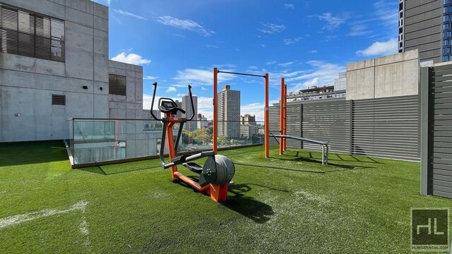 view of jungle gym featuring a city view, a lawn, and fence