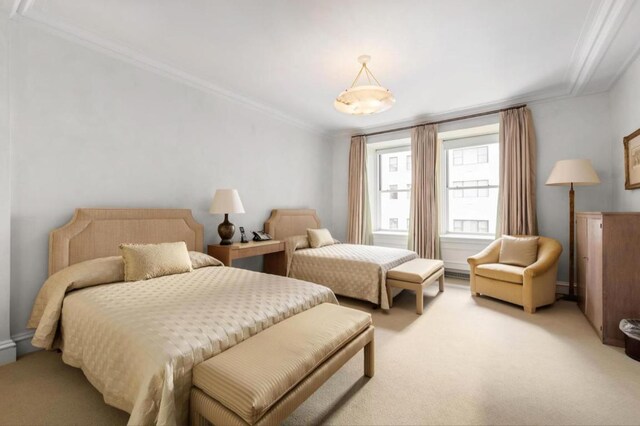 bedroom with ornamental molding and carpet flooring