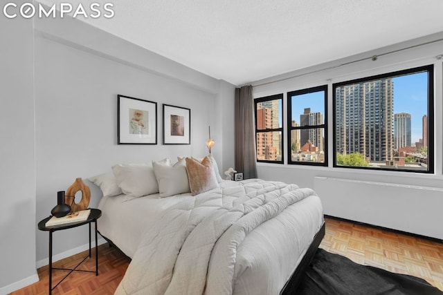 bedroom featuring parquet flooring and a textured ceiling