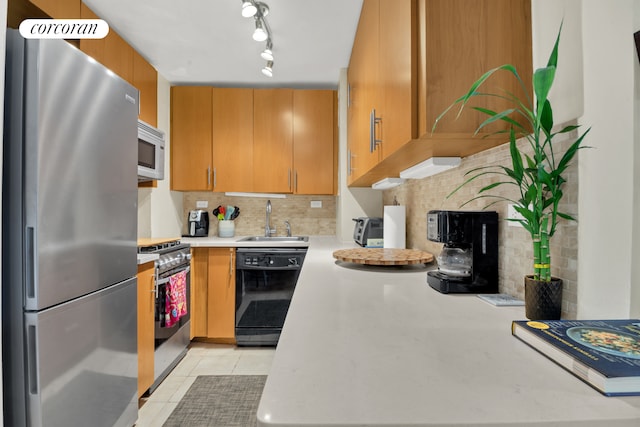 kitchen featuring light tile patterned floors, stainless steel appliances, tasteful backsplash, and a sink