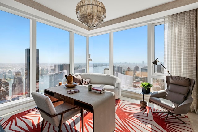 sunroom / solarium with a water view, an inviting chandelier, and a city view