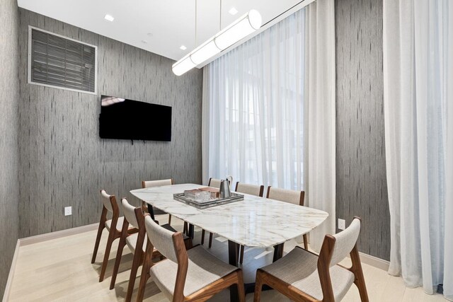 dining room with baseboards, light wood-style flooring, and wallpapered walls