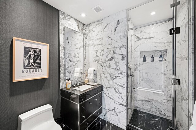 bathroom featuring toilet, a marble finish shower, vanity, and recessed lighting