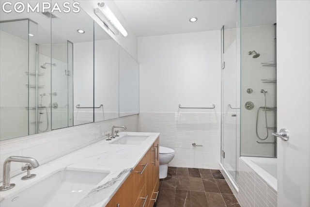 full bathroom featuring toilet, vanity, tile walls, separate shower and tub, and tile patterned floors