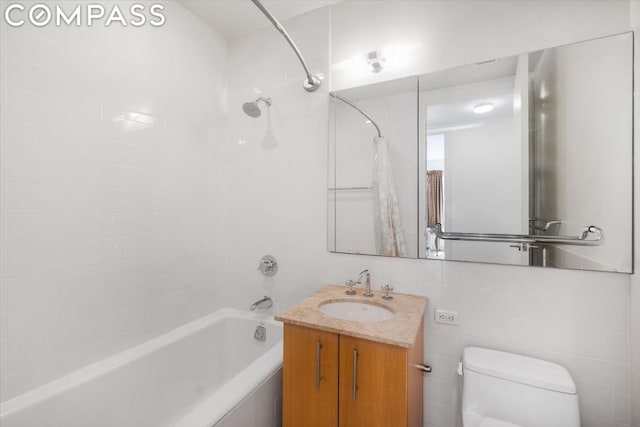 full bathroom with toilet, tiled shower / bath combo, tile walls, and vanity