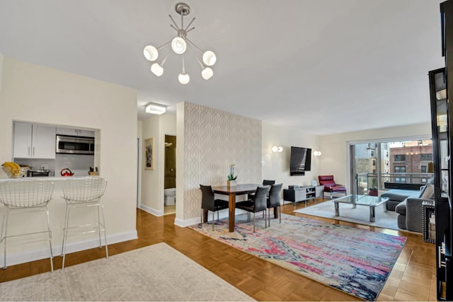 dining area featuring baseboards and a chandelier