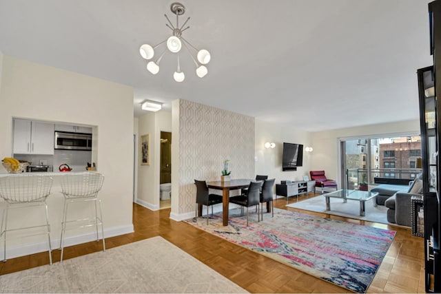 living area with a chandelier and baseboards