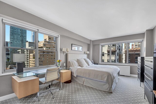 bedroom featuring multiple windows, baseboards, and an office area