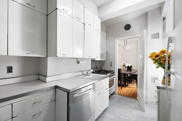 kitchen featuring appliances with stainless steel finishes, sink, and white cabinets