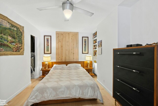 bedroom with baseboards, light wood-style flooring, and a ceiling fan