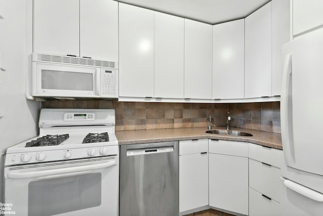 kitchen featuring white appliances, tasteful backsplash, white cabinets, light countertops, and a sink