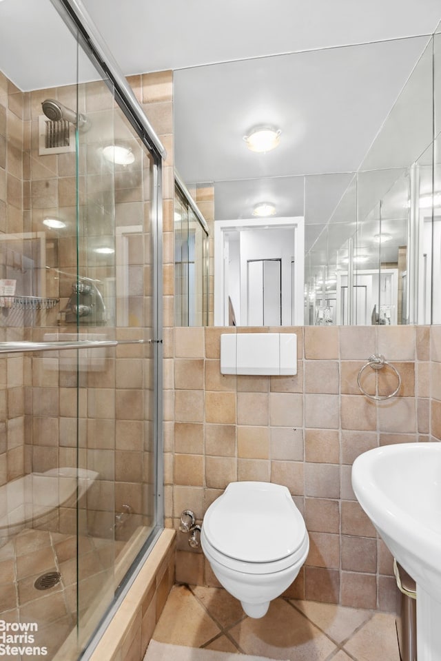 full bath featuring a stall shower, tile walls, and tile patterned floors