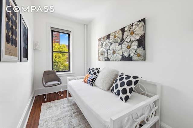 bedroom with wood finished floors and baseboards